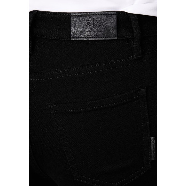 Detalle de etiqueta Armani Exchange en vaqueros negros de mujer