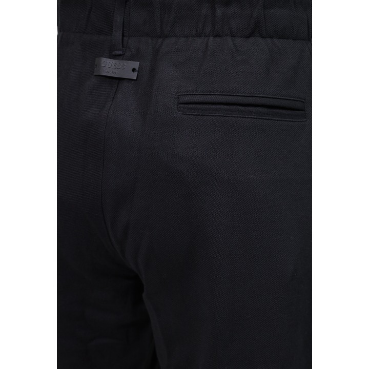 Detalle Guess pantalón negro de hombre con bolsillo posterior y tejido diagonal