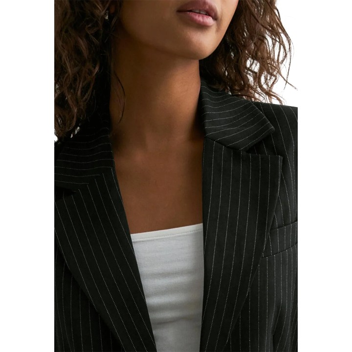 Detalle del cuello y las rayas diplomáticas de la chaqueta Only negra
