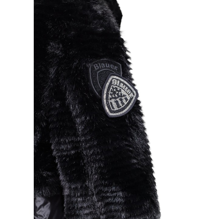 Detalle del parche Blauer. en manga de chaqueta negra de mujer de tejido efecto pelo