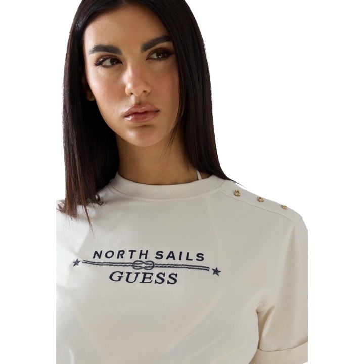 Detalle de camiseta Guess de mujer color crema con logo y botones dorados