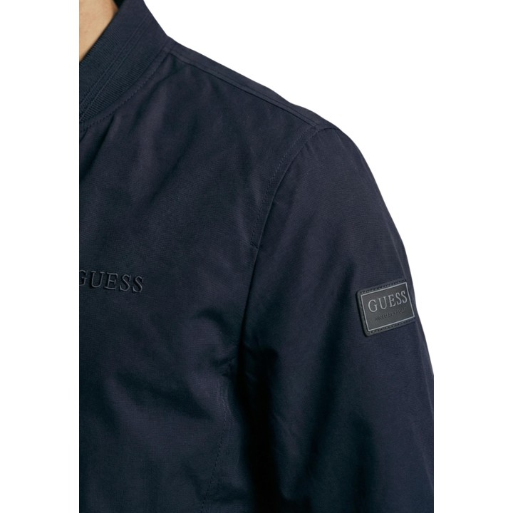 Detalle de manga de chaqueta bomber azul Guess para hombre con parche