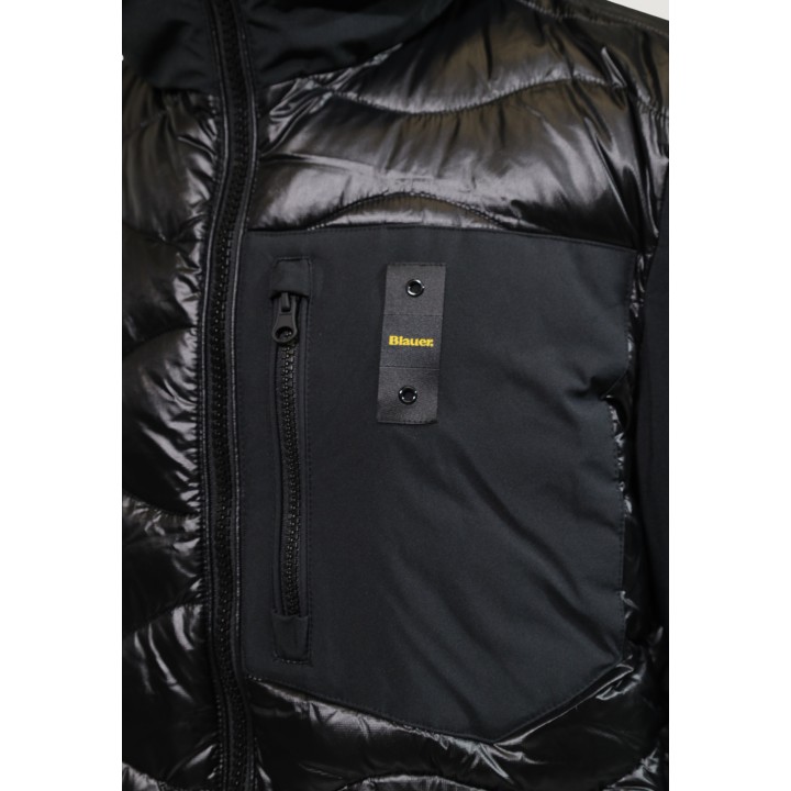 Detalle frontal de chaqueta Blauer. acolchada negra de hombre con bolsillo y logo