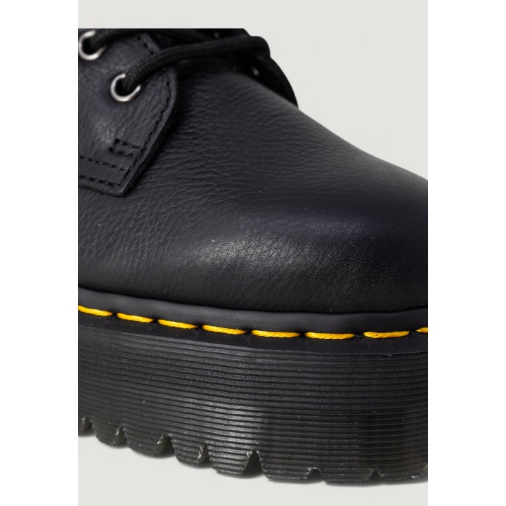 Detalle de la suela dentada y costuras amarillas de la bota Dr. Martens Jadon negra