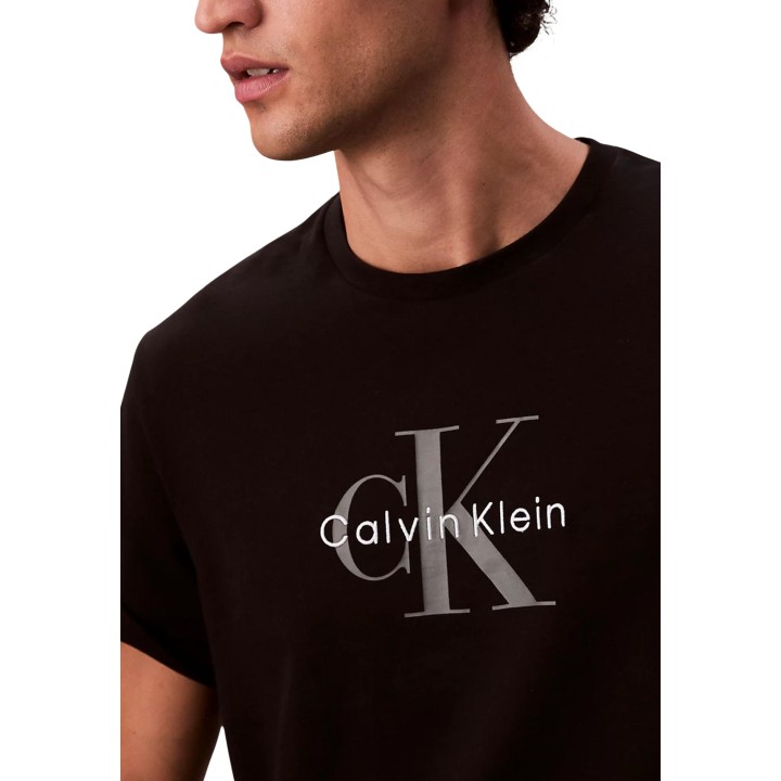 Detalle del logo Calvin Klein Jeans en camiseta negra de hombre