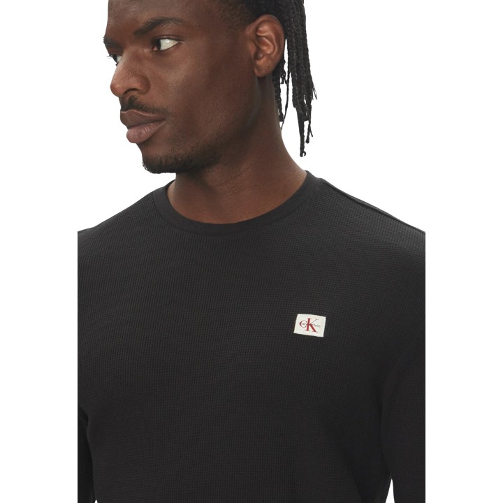 Detalle de camiseta negra Calvin Klein Jeans de hombre con tejido waffle y logo