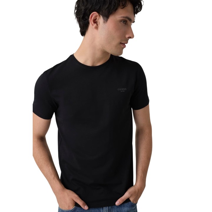 Detalle frontal de camiseta Guess negra de hombre con logo discreto