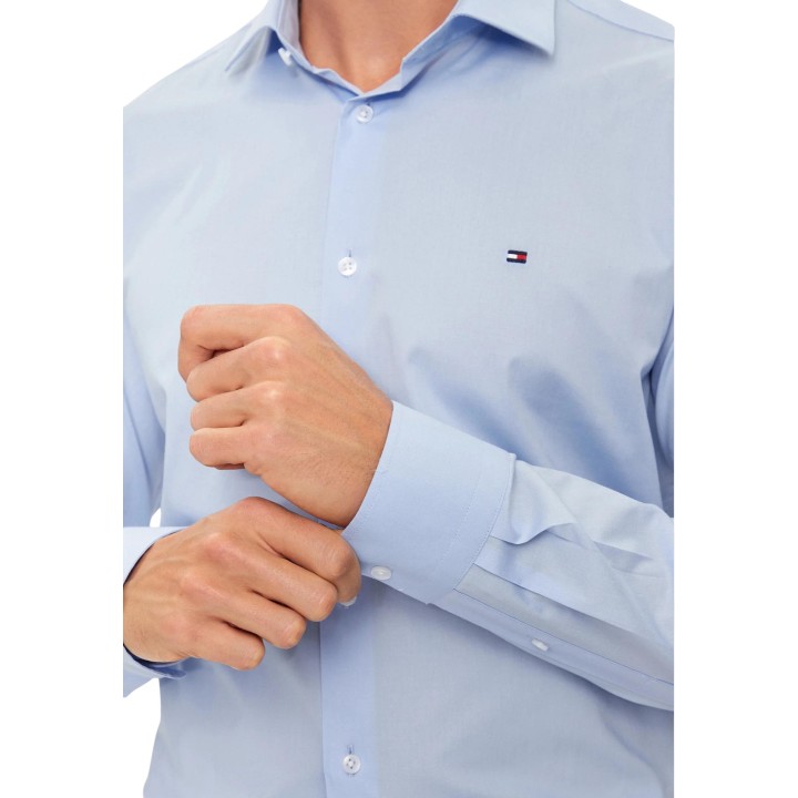 Detalle de puño y logo en camisa Tommy Hilfiger azul de popelín