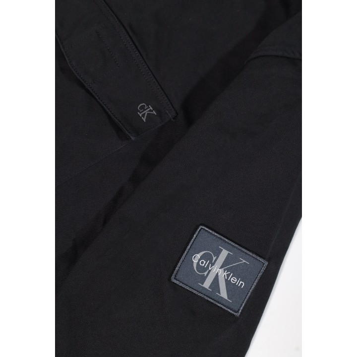 Detalle del logo Calvin Klein Jeans en camisa negra para hombre LV04RG121G
