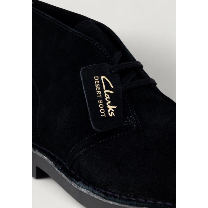 Detalle de cordones y etiqueta de bota Clarks Desert Boot negra