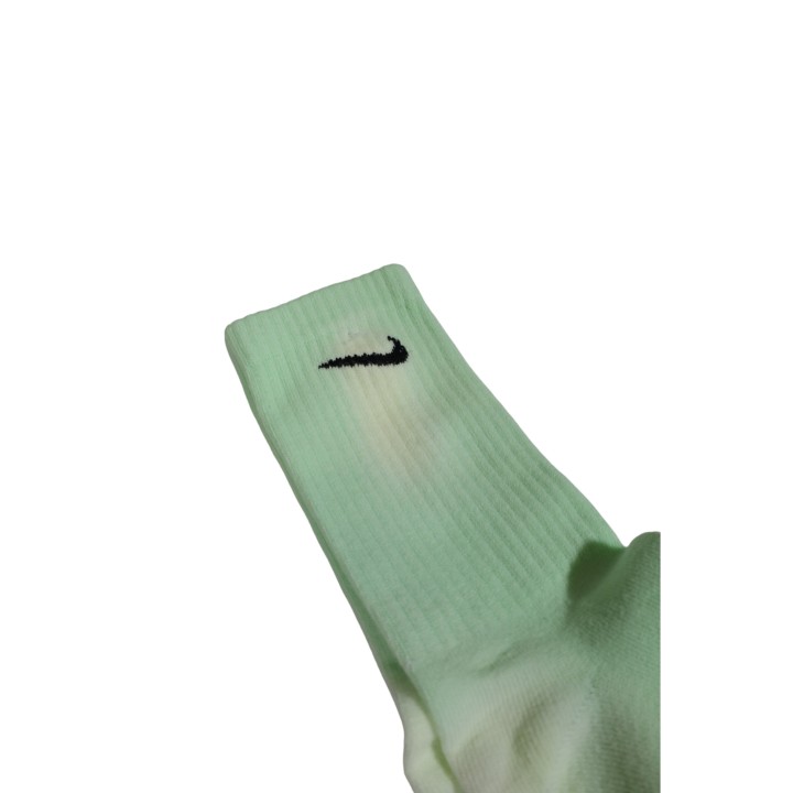 Detalle del logo Nike en calcetín verde flúor para hombre