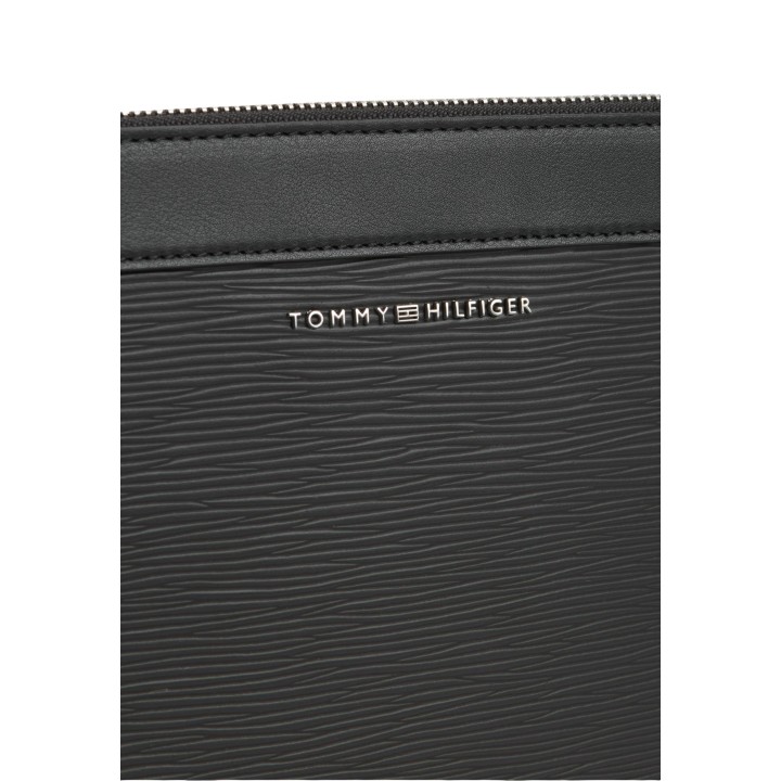 Detalle del logo Tommy Hilfiger en bolso negro de material saffiano