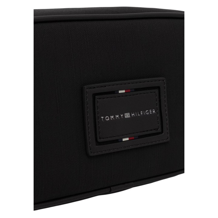 Detalle del logo Tommy Hilfiger en neceser negro de tela