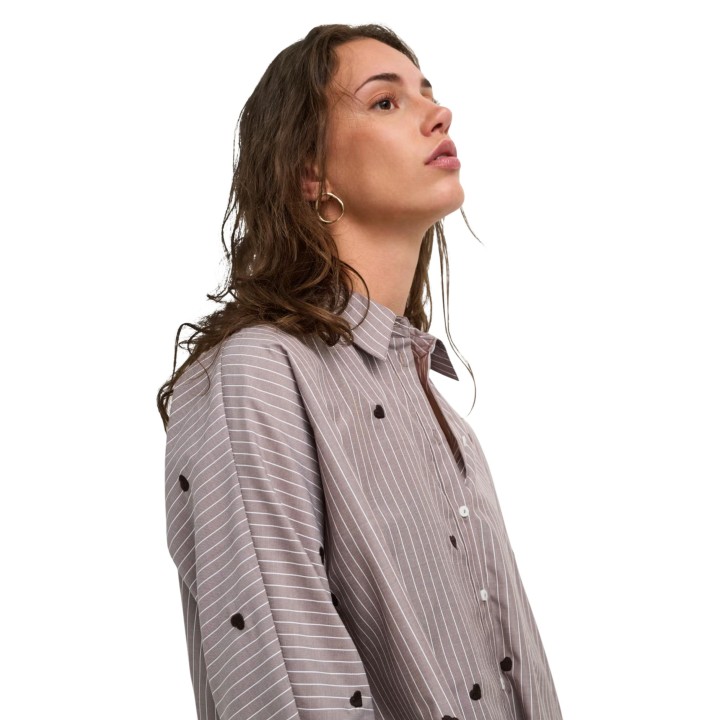 Detalle de camisa Only de mujer color café con rayas y corazones vista de tres cuartos