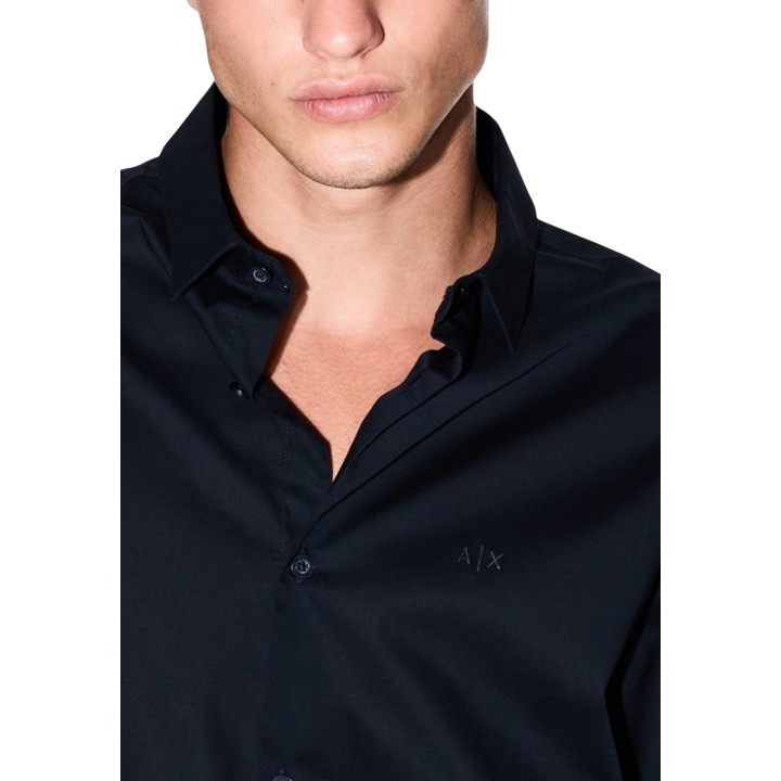 Detalle frontal del cuello y logo de camisa azul Armani Exchange de hombre