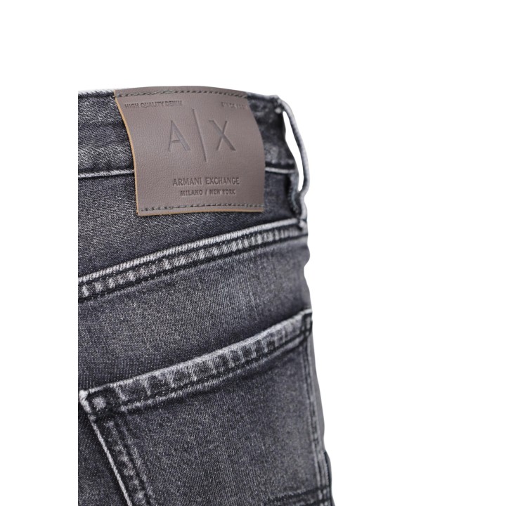 Detalle de etiqueta Armani Exchange en pantalón vaquero negro de hombre