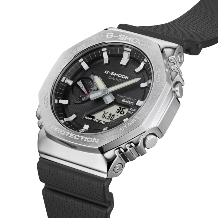 Reloj Casio G-Shock GBM-2100-1A con bisel metálico plateado y correa negra, vista tres cuartos